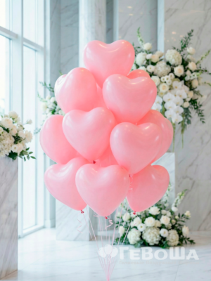 Букет из светло-розовых латексных шаров в форме сердца с лентами в интерьере вид спереди